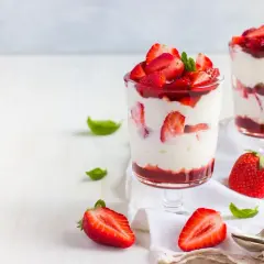 Pyszne desery z truskawkami i kremem mascarpone, ozdobione listkami mięty. Idealne na letnie popołudnie.