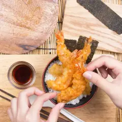 Ręce sięgają po chrupiące krewetki w cieście. To właśnie tempura – japoński przysmak.