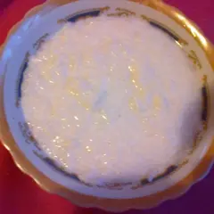 Płatki ryżowe na mleku w ozdobnej miseczce. Pyszne, domowe śniadanie.