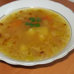 Prosta zupa cebulowa z ziemniakami, z dodatkiem marchewki i ziół, podana w białej misce.