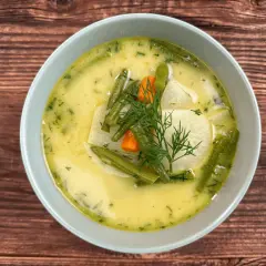 Aksamitna zupa z kalarepy z fasolką szparagową i marchewką, udekorowana koperkiem.
