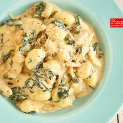 Pyszne gnocchi z kurczakiem i szpinakiem w kremowym sosie, posypane parmezanem. Idealne danie na szybki obiad.