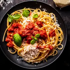 Pyszne spaghetti z sosem pomidorowym, parmezanem i bazylią. Idealny przepis na sos do spaghetti, który zachwyci każdego.