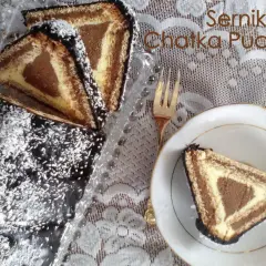 Sernik Chatka Puchatka, ciasto z sera z wiaderka, z polewą czekoladową i wiórkami kokosowymi. Na talerzyku kawałek ciasta.