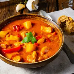 A miseczka parującej zupy gulaszowej, pachnącej jak zupa gulaszowa przepis babci. Ziemniaki, papryka i mięso w aromatycznym sosie.