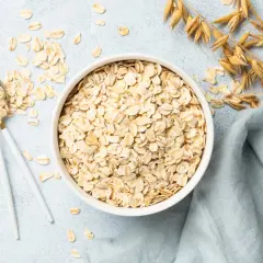 Misternie ułożone płatki owsiane w misce i na łyżce. Czy płatki owsiane mają gluten? Zwykłe płatki owsiane zawierają gluten, chyba że są certyfikowane jako bezglutenowe.