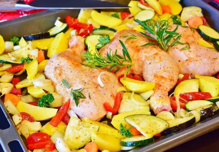 Gotowe do pieczenia: pieczone udka z kurczaka z ziemniakami, cukinią, papryką i ziołami.