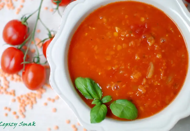 Zupa pomidorowa z soczewicą, ozdobiona bazylią. Obok gałązka pomidorków i rozsypana soczewica. Idealna na chłodne dni, smakuje jak domowe pesto pomidorowe.