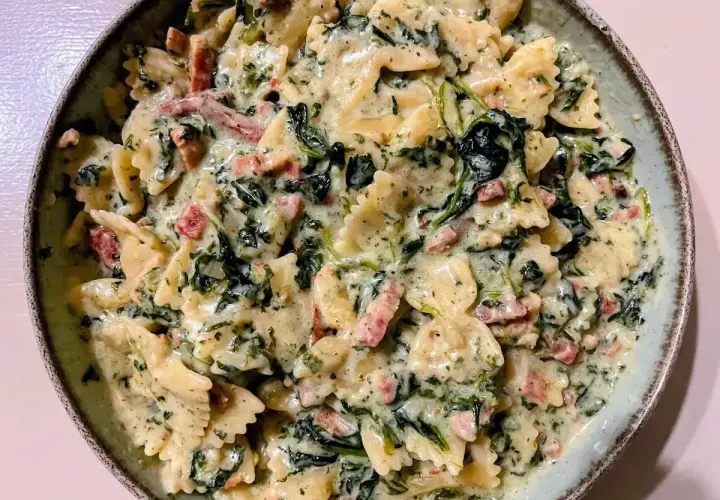 Makaron farfalle w kremowym sosie szpinakowym z kawałkami boczku. Pyszne danie, które zachwyci każdego.