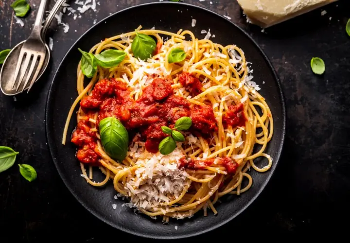 Pyszne spaghetti z sosem pomidorowym, parmezanem i bazylią. Idealny przepis na sos do spaghetti, który zachwyci każdego.