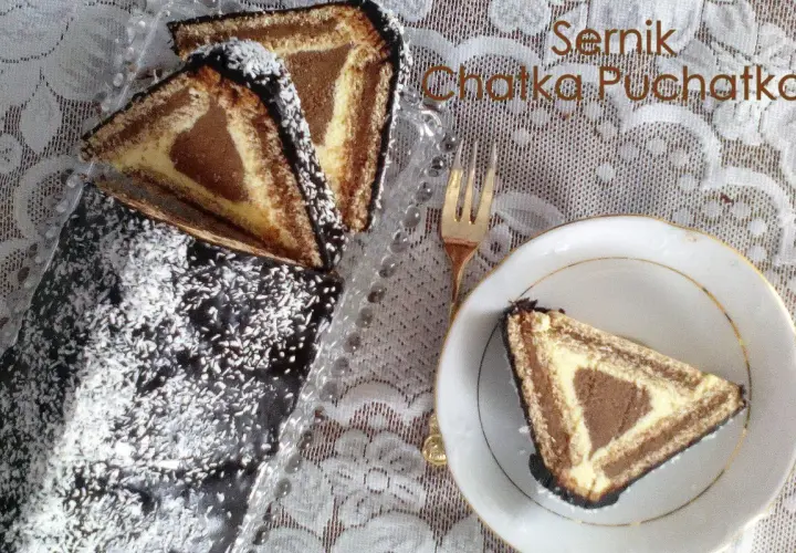 Sernik Chatka Puchatka, ciasto z sera z wiaderka, z polewą czekoladową i wiórkami kokosowymi. Na talerzyku kawałek ciasta.