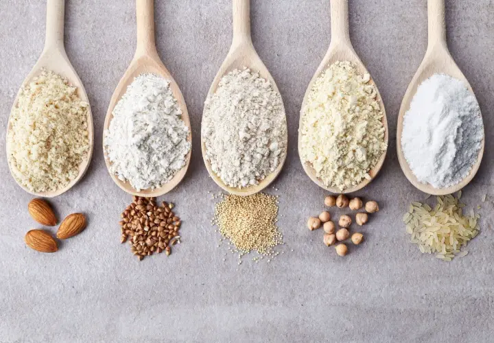 Pięć drewnianych łyżek z mąkami bezglutenowymi: migdałową, gryczaną, z amarantusa, z ciecierzycy i ryżową. Idealne do diety celiakia.