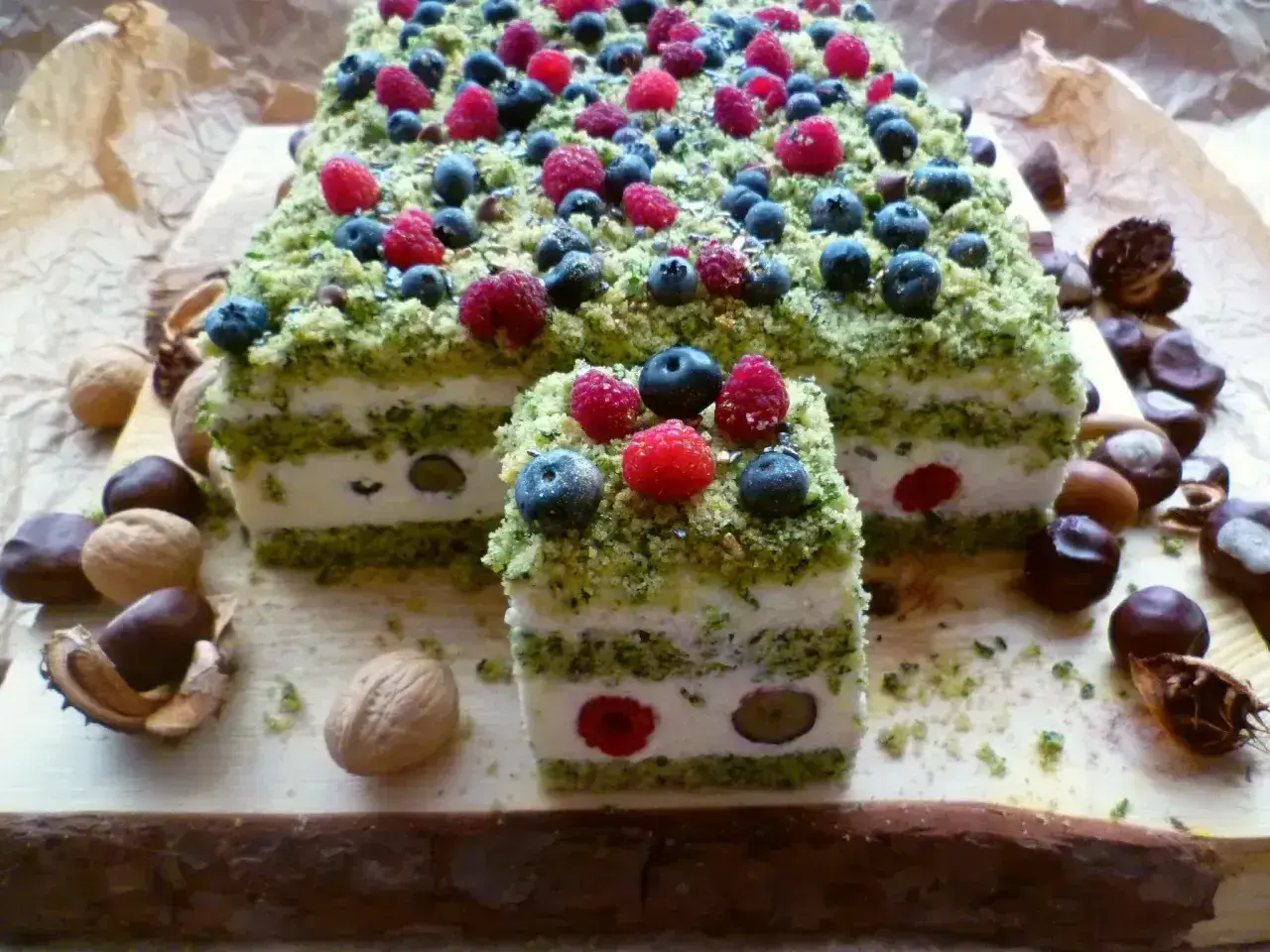 Ciasto leśny mech na dużą blachę z serkiem mascarpone, udekorowane malinami i borówkami. Wygląda jak leśna polana.