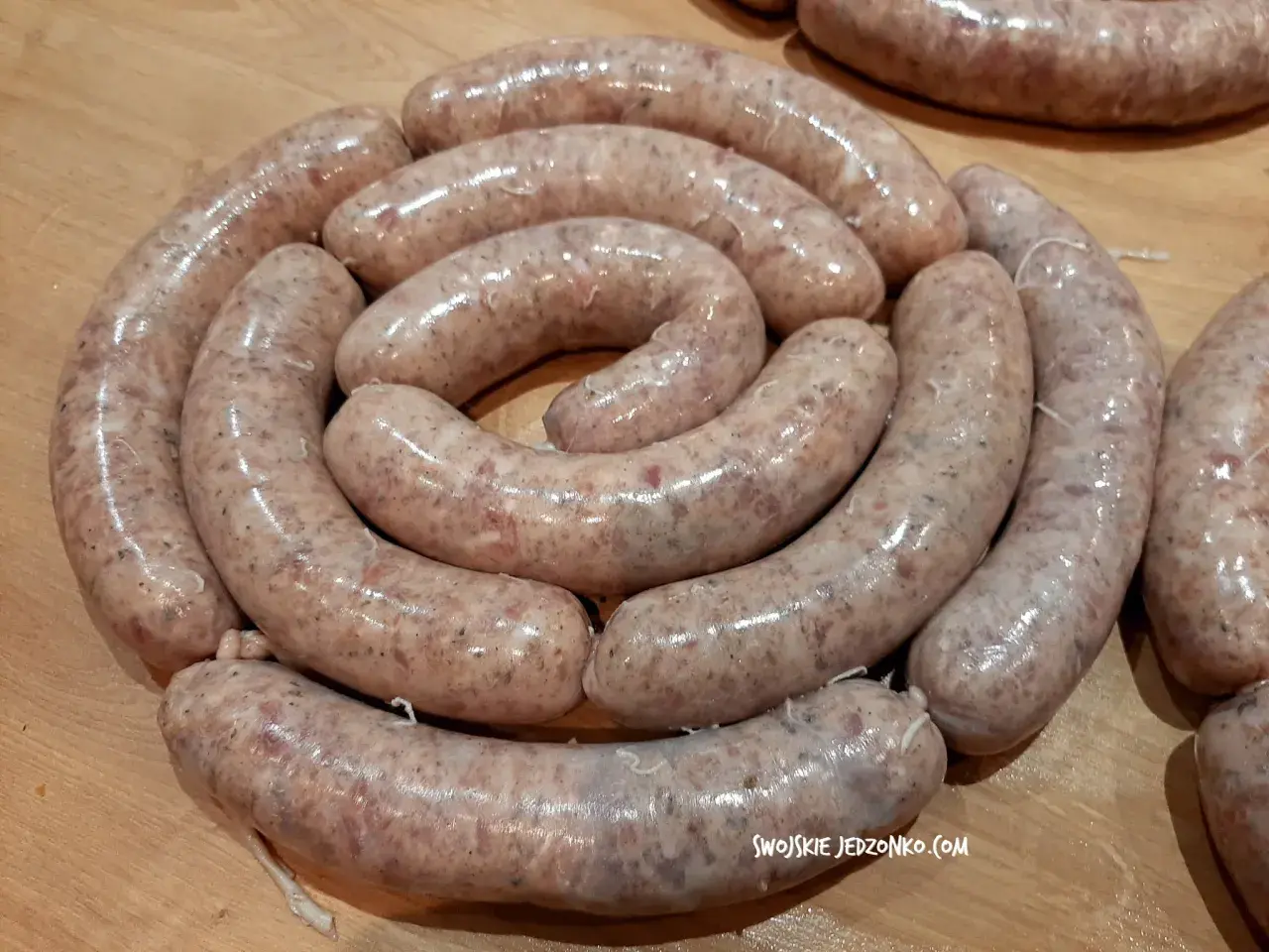 Świeża biała kiełbasa ułożona w okręgu, gotowa na przepis na 3 kg. Idealna na świąteczny stół.