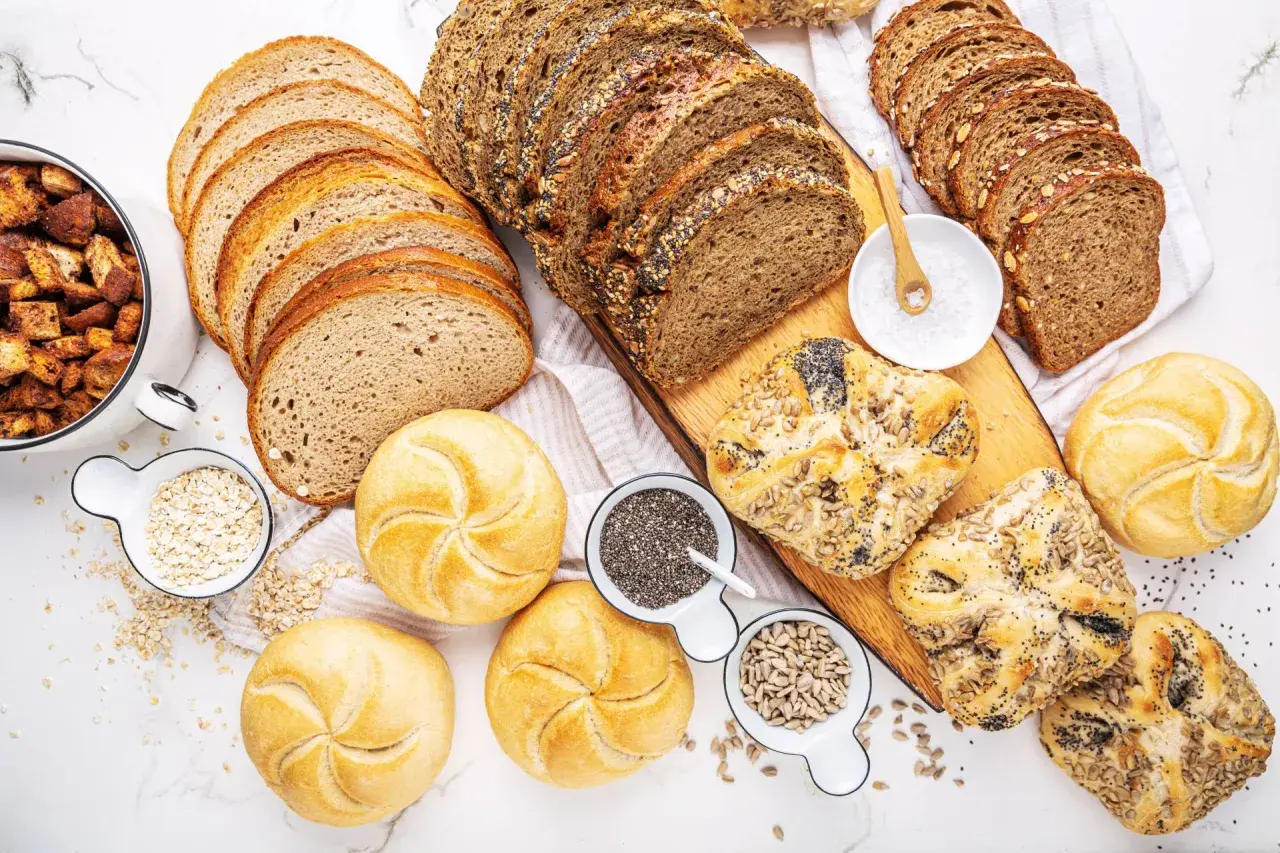 Różne rodzaje pieczywa, od kromek chleba po bułeczki, pokazują, że gluten to główny składnik wielu wypieków.