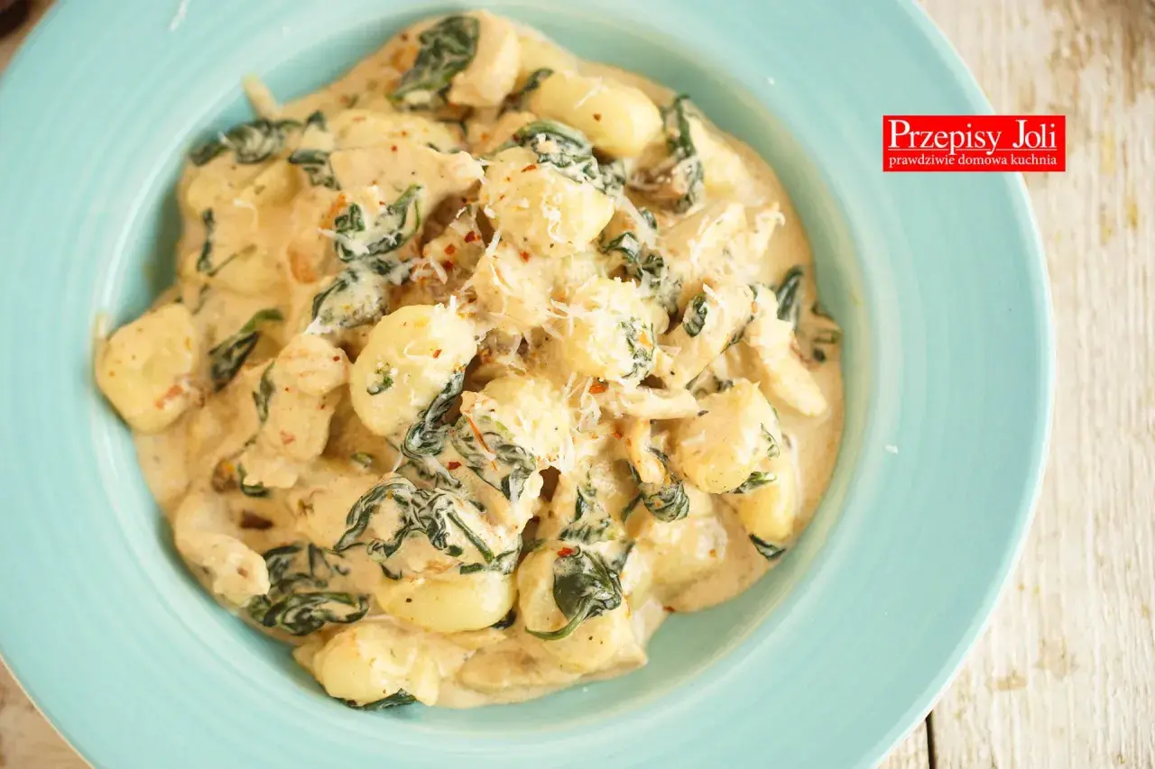 Pyszne gnocchi z kurczakiem i szpinakiem w kremowym sosie, posypane parmezanem. Idealne danie na szybki obiad.