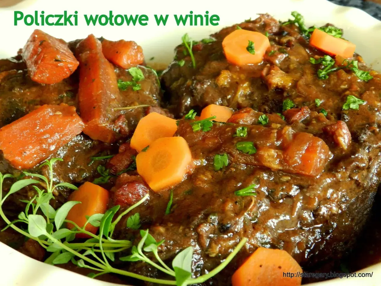 Policzki wołowe w winie, pyszne danie z przepisu Okrasy, z marchewką i ziołami.