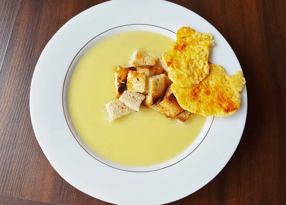 Prosta zupa cebulowa z ziemniakami, podana z chrupiącymi grzankami i serowymi chipsami. Idealna na chłodne dni.