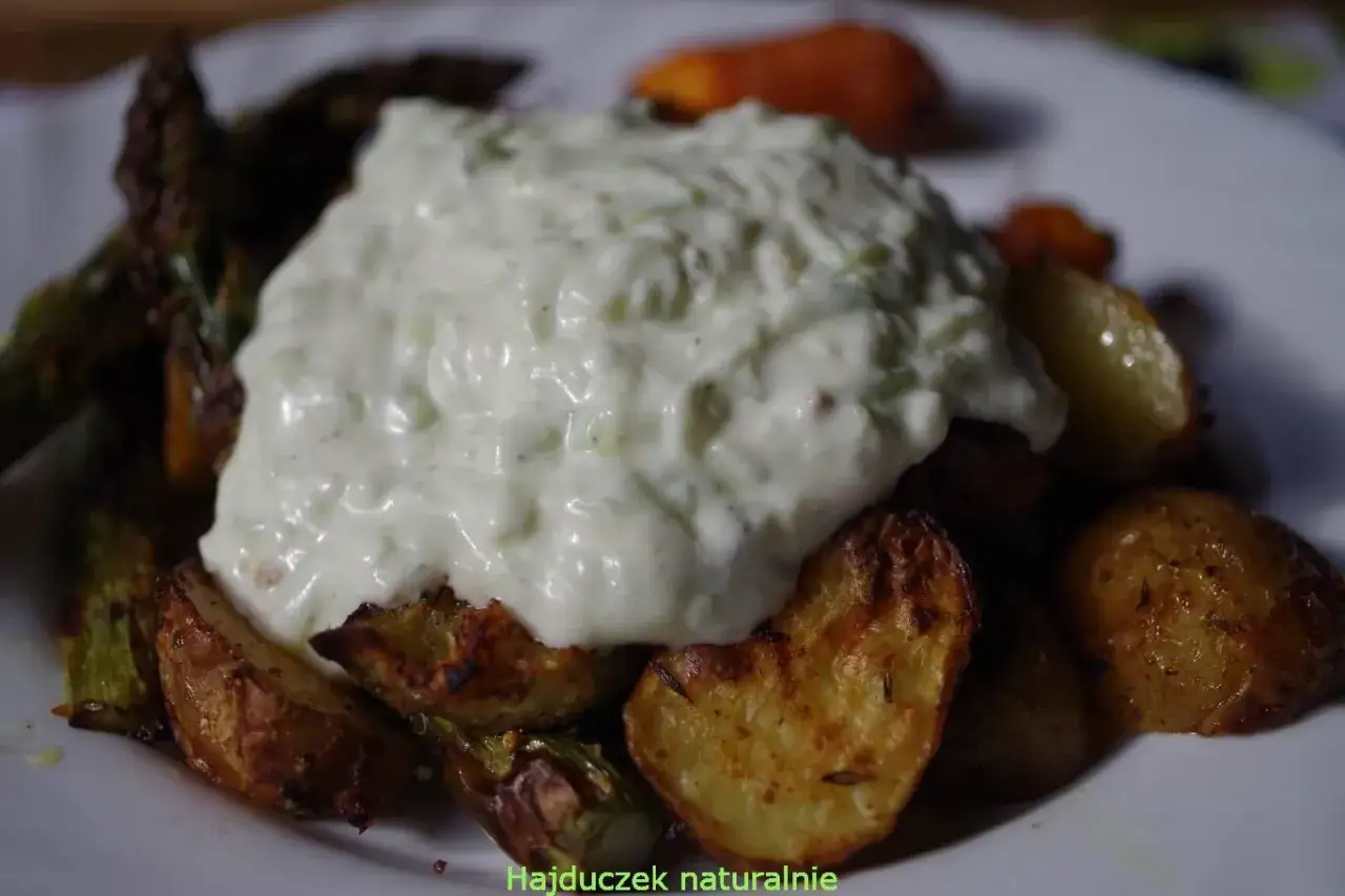 Pieczone ziemniaki i szparagi z kremowym sosem, który wygląda jak domowe tzatziki. Idealny dodatek do obiadu.